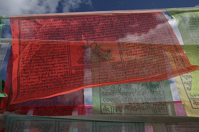 Colorful prayer flags with intricate script and symbols fluttering in the wind, capturing a vibrant cultural scene.