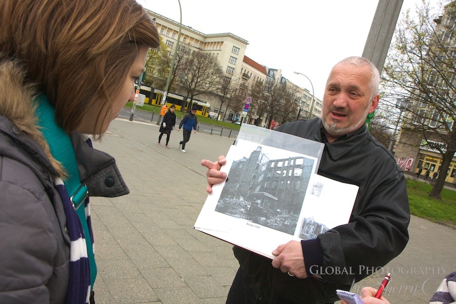 Tour leader showing old photos of Berlin during cold war