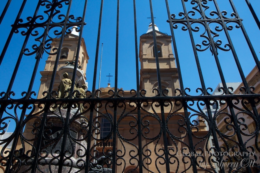 An iron gate entry in front of a neighborhood church