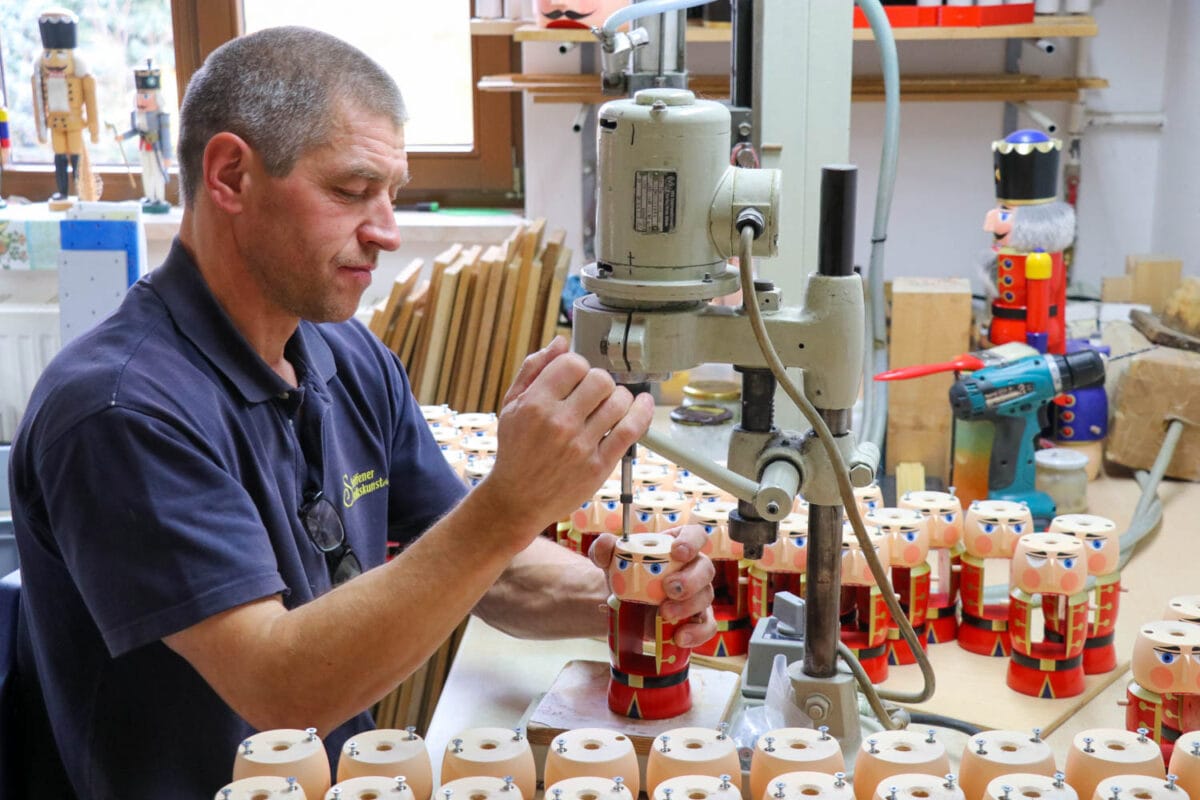 Man works on nutcracker with a drill