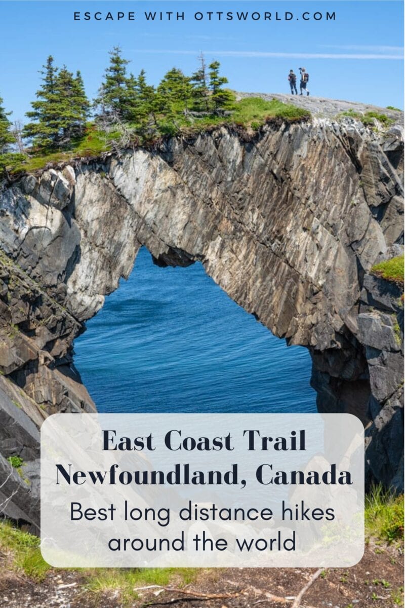 Scenic view of the East Coast Trail in Newfoundland, Canada, featuring a natural rock arch over the ocean with hikers on top, showcasing outdoor adventure and coastal landscapes.
